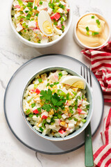 Traditional Russian salad with crab sticks, eggs and corn