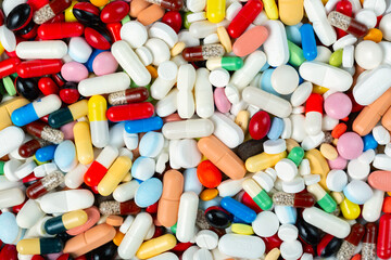 Health care and treatment concept. Huge pile of colorful pills, tablets and capsules background