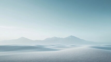 Serene Winter Landscape: Snow-Covered Dunes and Distant Mountains