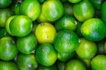 Many lime citrus fruits at a fruit market. Food background. Top view