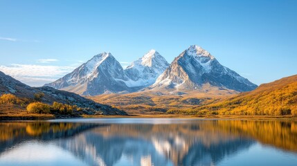 The landscape features towering mountains standing majestically against the clear blue sky, their peaks covered with a dusting of snow