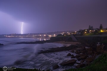 Lightning strikes coastal town night scene natural phenomenon dramatic atmosphere wide view weather impact