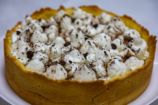 Traditional banoffee cake with banana and caramel sauce filling sprinkled with grated dark chocolate and coffee . English traditional pie