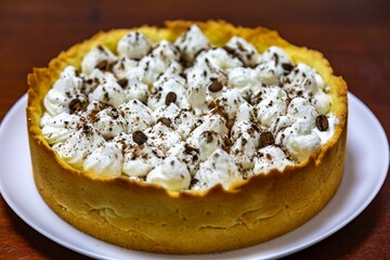 Traditional banoffee cake with banana and caramel sauce filling sprinkled with grated dark chocolate and coffee . English traditional pie
