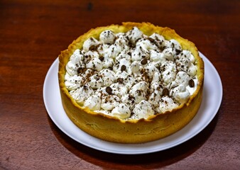 Traditional banoffee cake with banana and caramel sauce filling sprinkled with grated dark chocolate and coffee . English traditional pie