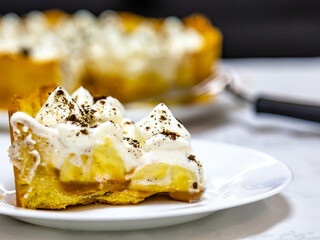 Traditional banoffee cake with banana and caramel sauce filling sprinkled with grated dark chocolate and coffee . English traditional pie