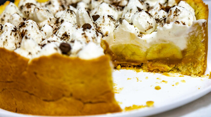 Traditional banoffee cake with banana and caramel sauce filling sprinkled with grated dark chocolate and coffee . English traditional pie