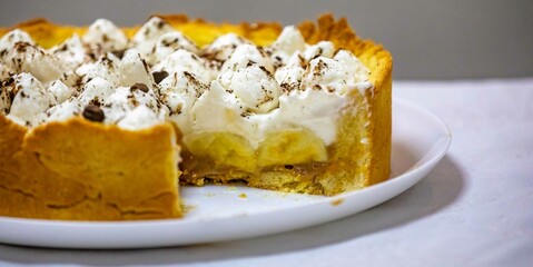 Traditional banoffee cake with banana and caramel sauce filling sprinkled with grated dark chocolate and coffee . English traditional pie