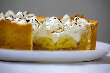 Traditional banoffee cake with banana and caramel sauce filling sprinkled with grated dark chocolate and coffee . English traditional pie
