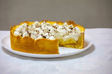 Traditional banoffee cake with banana and caramel sauce filling sprinkled with grated dark chocolate and coffee . English traditional pie