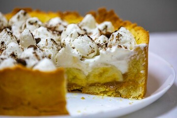 Traditional banoffee cake with banana and caramel sauce filling sprinkled with grated dark chocolate and coffee . English traditional pie
