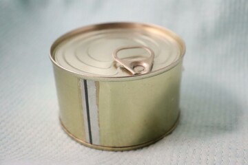 A sealed metal can with a pull-tab, placed on a white surface.