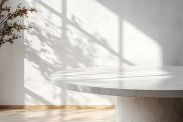 Minimalist round marble table with soft natural light and abstract shadow on white wall for product display