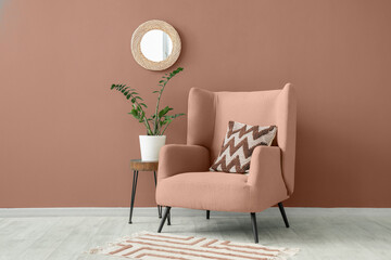 Interior of living room with mirror, armchair and plant