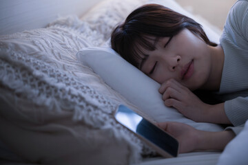スマホを見ながら寝落ちしてしまった女性