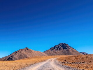 Naklejka premium Remote mountain trails under clear blue sky, early morning light, wide-angle view capturing adventure spirit