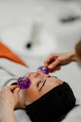 Woman receiving facial treatment with glass tools at a spa