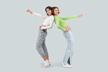 Young women in jeans on light background