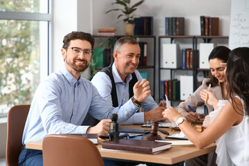 Male lawyer working with colleagues at table in office