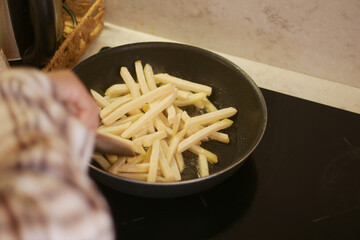 Cooking Delicious French Fries in a Pan on the Stove for a Tasty Meal