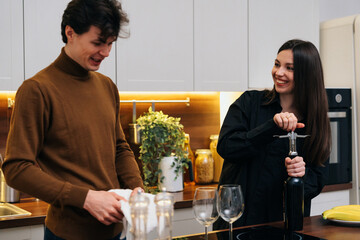 Young couple preparing to enjoy wine together in a modern kitchen