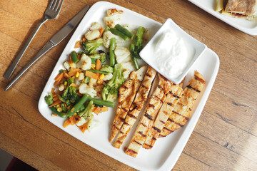 Delicious Grilled Chicken Paired with Fresh Vegetables and a Creamy Yogurt Sauce
