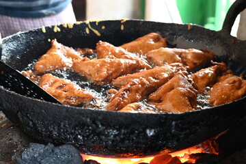 Bread pakora is being fried in hot oil. It is made by stuffing the bread with potatoes and dipping it in the batter of chickpea flour and then frying it. popular snack of India. Indian street food. 
