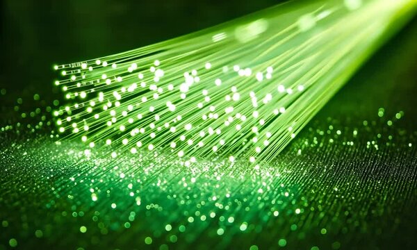 A close-up of glowing green optical fibers emitting light, creating a vibrant and dynamic visual effect, often used in telecommunications and data transmission.