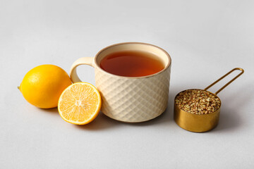 Cup of hot buckwheat tea with lemon on grey background