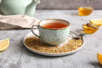 Cup of hot buckwheat tea with lemon on grunge background