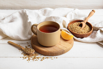 Cup of hot buckwheat tea with lemon on white wooden background