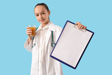 Teenage doctor with juice and blank clipboard on blue background