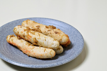 Traditional Indonesian Food, known as otak-otak ikan. Made from fish and served on the grey or gray plate. Close up view. Isolated on white background.