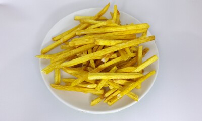 Taro fried sticks isolated in white plate. Asian traditional snack made of taro. Crispy taro chips flat lay background.