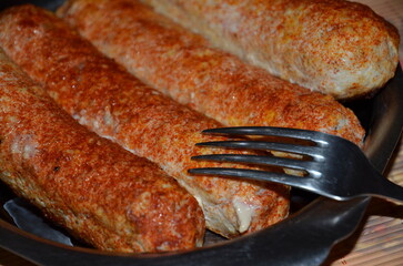 
Lula kebab on a stainless steel plate and fork.