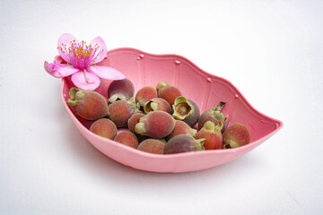 Photo of kemunting or karamunting with flowers in a pink leaf-shaped plate
