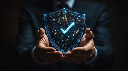 Secure Future:  A businessman's hands gently cradle a glowing shield, its blue digital checkmark symbolizing guaranteed protection and peace of mind.
