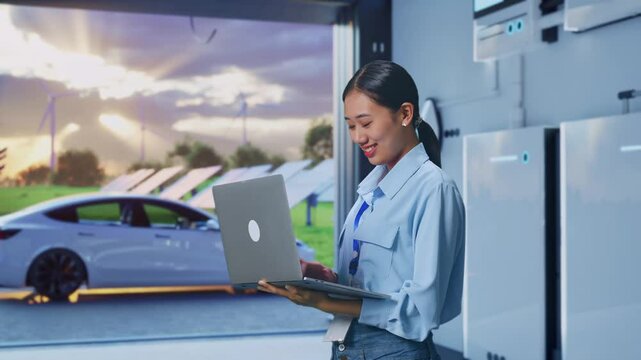 Side View Of Asian Female With Her Laptop With Home Energy Storage System In a Modern Garage, Typing On Her Laptop'S Keybaord With Meditation