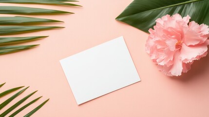 Obraz premium A delicate pink flower rests atop a pristine white card, both set against a soft pink background, evoking love and warmth perfect for Valentine's Day.