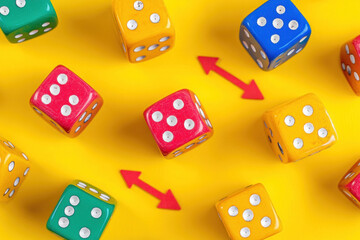 Colorful dice on yellow background: red, green, blue, yellow, and black, creating a vibrant and eye-catching contrast.