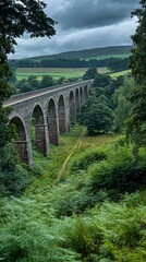 Stone viaduct over valley, nature trail, cloudy sky