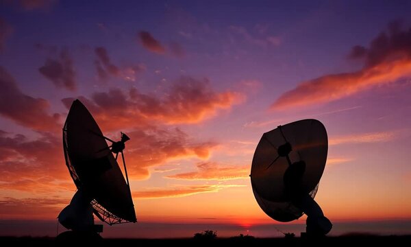 The image showcases two satellite dishes silhouetted against a vibrant sunset, highlighting the intersection of technology and nature.