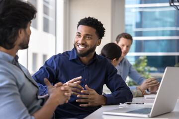 Positive handsome African American project manger man meeting with male Indian colleague at large...