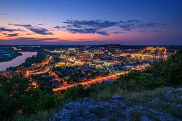 Vibrant City Skyline Illuminated at Dusk With River and Hills in the Background