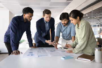 Diverse professional team working on marketing strategy together, analyzing statistic reports,...