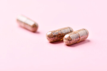 Siberian ginseng (Eleutherococcus senticosus) capsules on bright background. Soft focus. Close up. Copy space