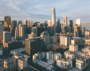 Aerial view of the San Francisco skyline featuring Salesforce Tower and modern skyscrapers illuminated by the setting sun