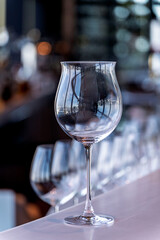 Wine and Drink glasses are arranged in front of drinks counter  bar with cityscape background
