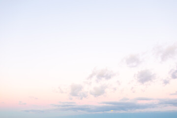 The sky fills with soft pastels as dawn arrives, showcasing delicate clouds and a gentle light emerging over the horizon, creating a tranquil atmosphere