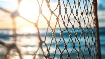 Beach volleyball net closeup against sunset and ocean waves creating a serene and vibrant atmosphere perfect for sports and leisure themes.